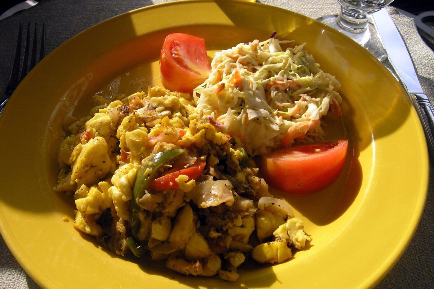 Ackee and saltfish with tomato on a yellow plate