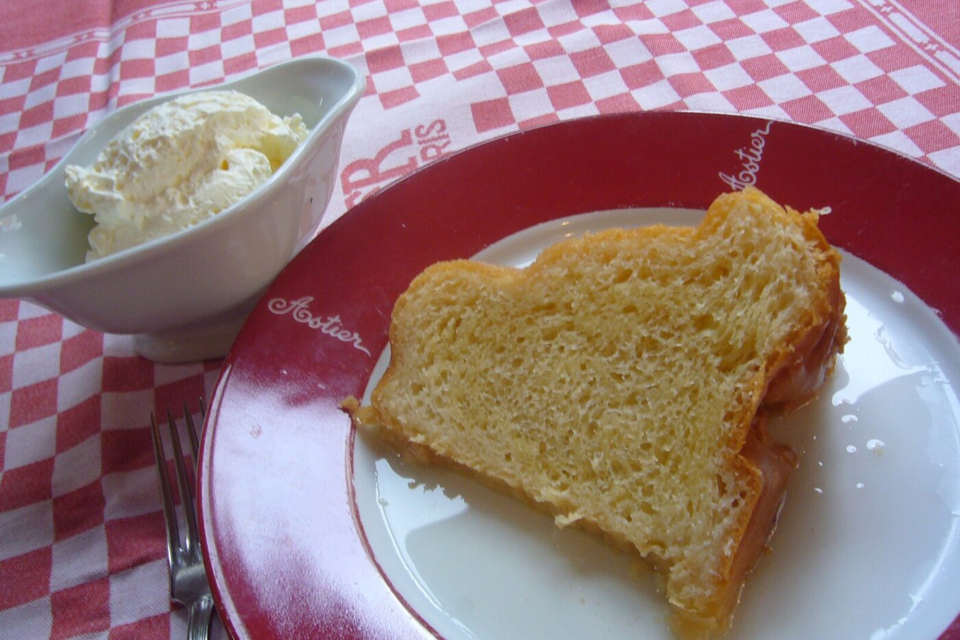 A slice of rum cake on a checked tablecloth